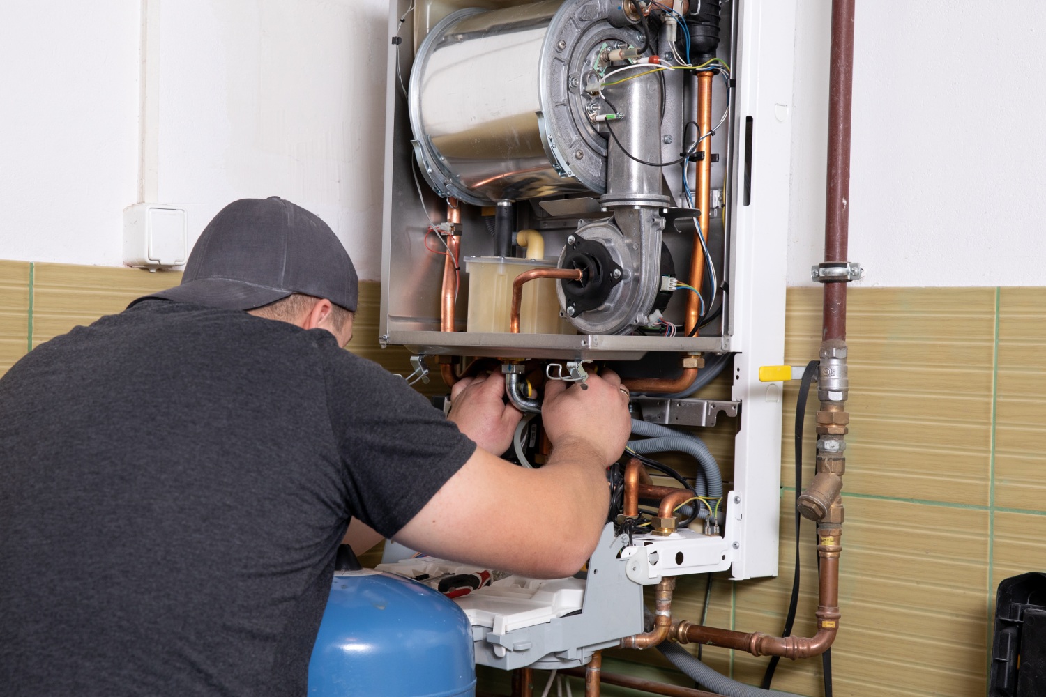 plumber fixing central heating system, Worker servicing a gas boiler