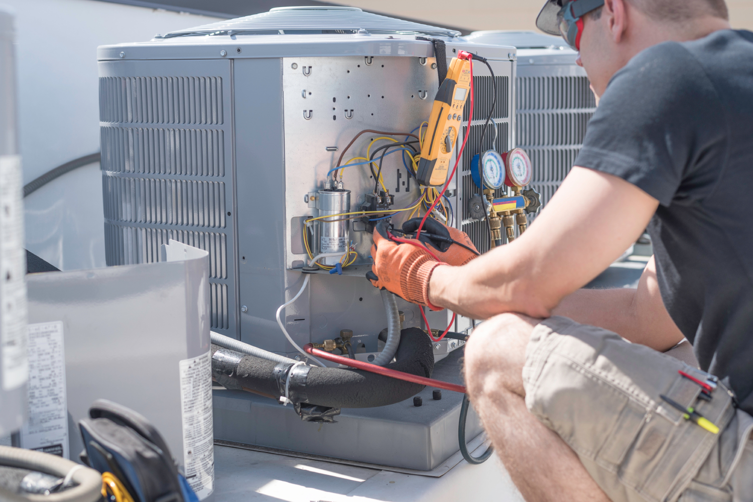 HVAC technician working on controls of air conditioner
