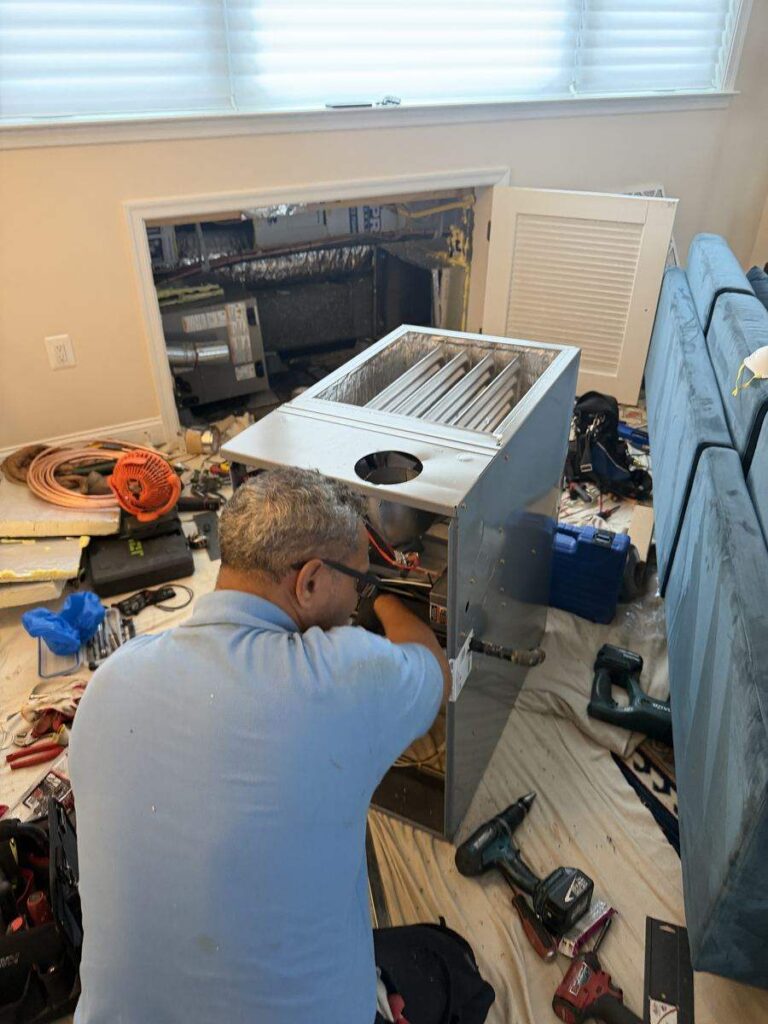 TC HVAC Services technician repairing an indoor furnace in Northern Virginia